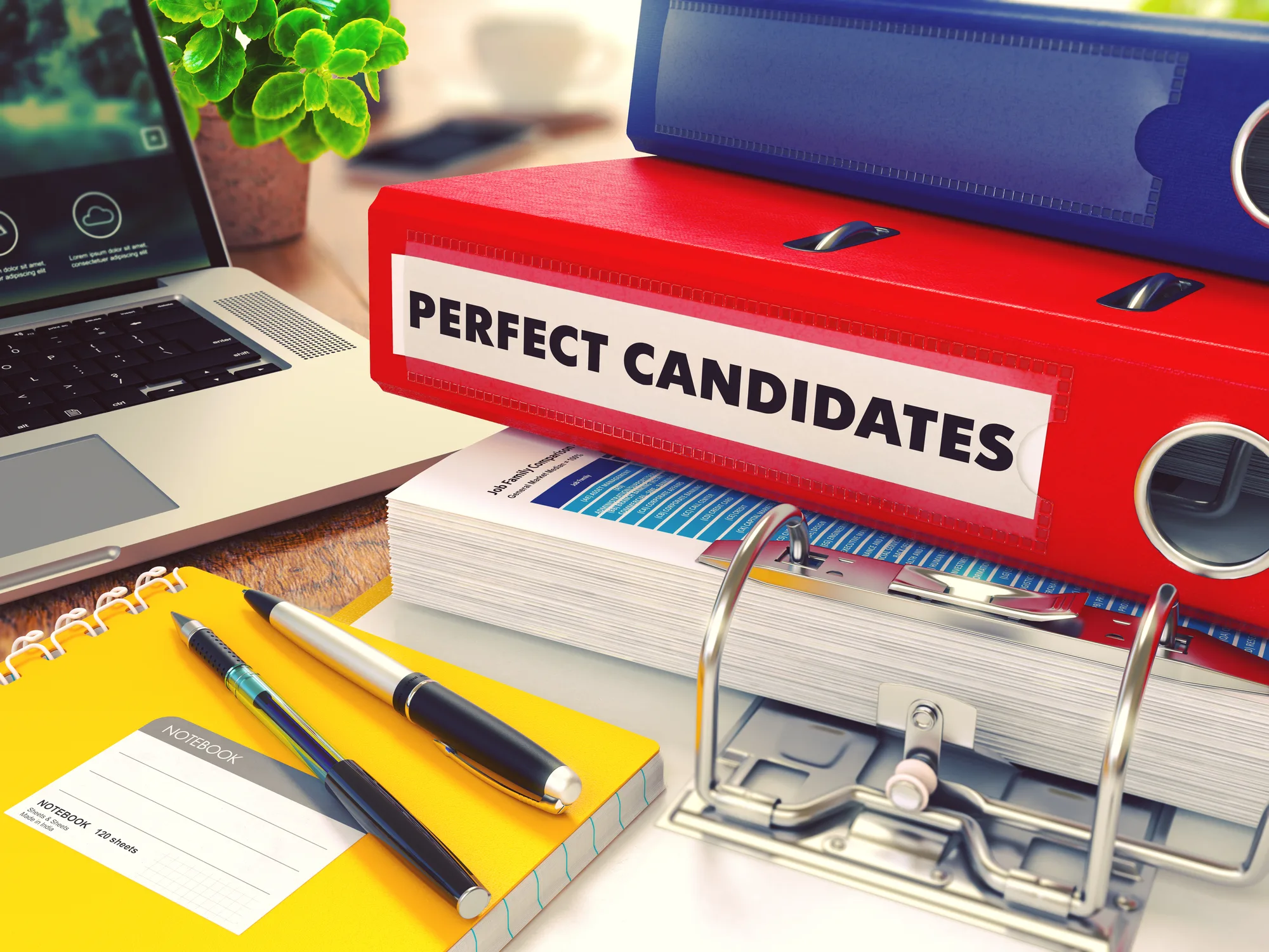Office folders labelled Perfect Candidates beside a laptop